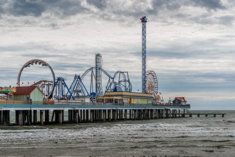 Colorful amusement rides on Galveston Pleasure Pier above the Gulf water