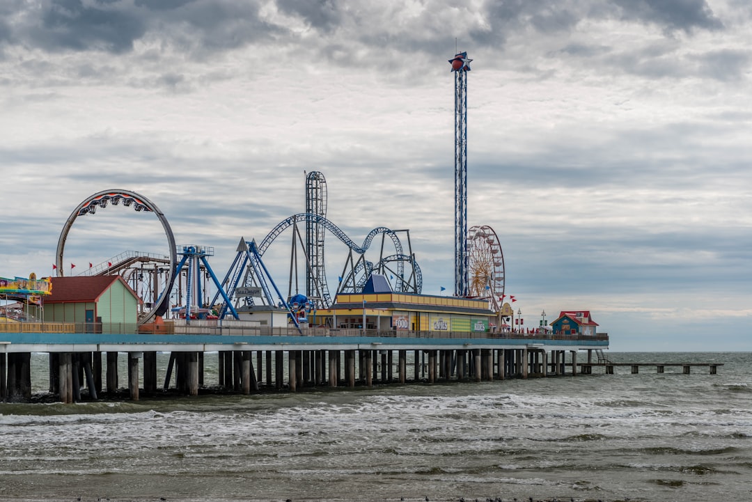 Colorful amusement rides on Galveston Pleasure Pier above the Gulf water